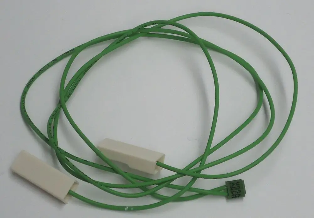 Grünes Kabel mit zwei weißen Anschlüssen, möglicherweise für Daikin Produkte, liegt auf einem hellen Hintergrund.